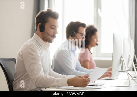 Service phone operators sitting at workplaces communicating with customers distantly Stock Photo