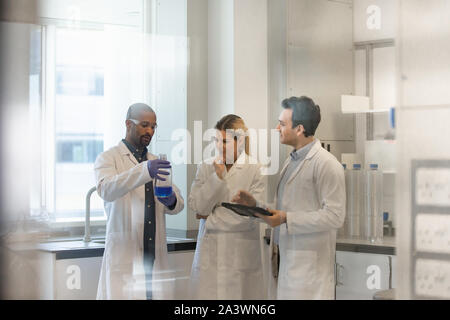 Team of scientists discussing experiment data on digital tablet Stock Photo