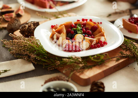Close-up of sweet cakes with berries on the plate decorated with herbs on the table Stock Photo