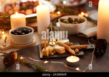 Close-up of appetizer from different kinds of cheese on the table decorated with candles for Christmas dinner Stock Photo