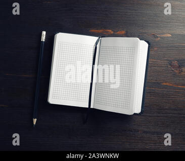 Opened blank notepad and pencil on wooden background. Flat lay. Stock Photo