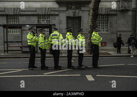 London, Westminster, UK. 7th Oct, 2019. Policemen stand on guard during the protest.Protesters took to the street in central London across this week and next week to highlight the 'climate emergency' facing the planet. Credit: Tom Barlow Brown/SOPA Images/ZUMA Wire/Alamy Live News Stock Photo