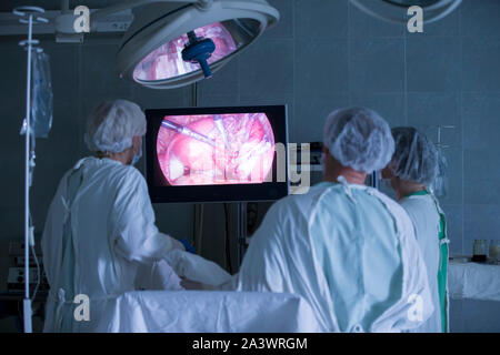 Doctors in the operating room doing laparoscopy. Surgeons operate on a patient. Medical professionals Stock Photo