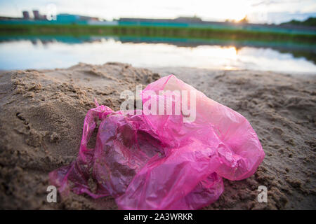 Cellophane package on the river bank. Environmental pollution.Garbage ...