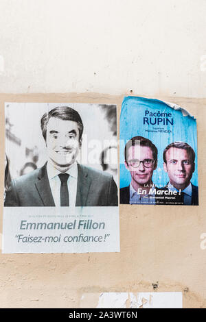 faded posters of 2017 french presidential elections showing francois fillon, emmanuel macron and pacome rupin Stock Photo