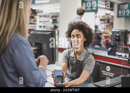 Sales clerk working at grocery store Stock Photo