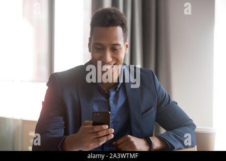 Smiling african american business man using phone in office Stock Photo