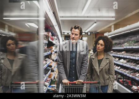 Couple choosing a ready meal in grocery store Stock Photo