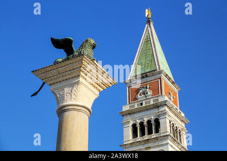 View of St Mark's Campanile and Lion of Venice statue at Piazzetta San Marco in Venice, Italy. Campanile is one of the most recognizable symbols of th Stock Photo
