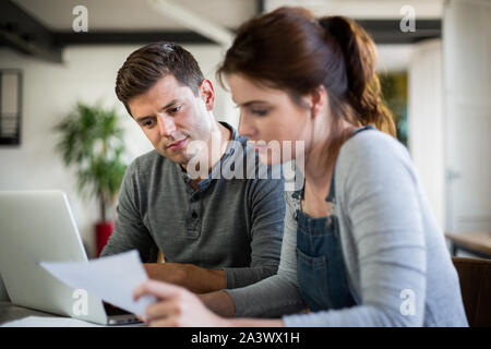 Young adult couple working on finance application together Stock Photo