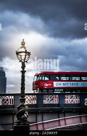 A red bus crossing the Lambeth bridge in London during a stormy day. Red bus in London Stock Photo