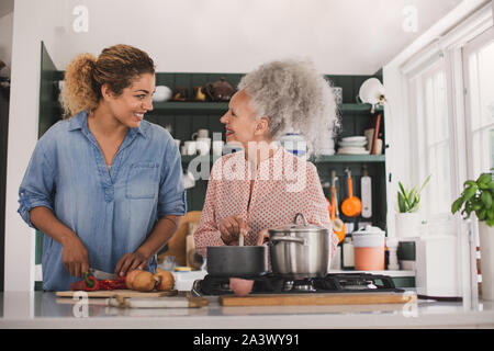 Senior adult woman cooking a meal with daughter