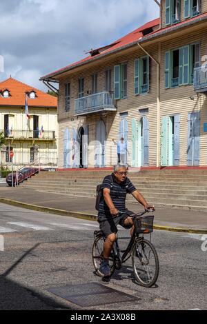 CYCLIST IN FRONT OF THE ALEXANDRE FRANCONIE MUSEUM, RUE REMIRE, CAYENNE, FRENCH GUIANA, OVERSEAS DEPARTMENT, SOUTH AMERICA, FRANCE Stock Photo
