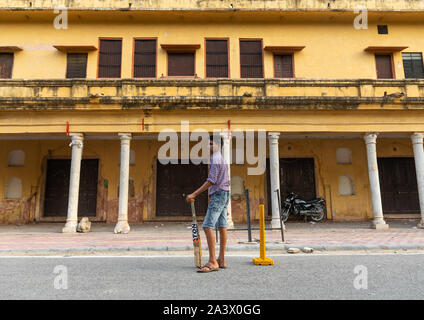 Young boy holding a cricket bat and playing in the street, Rajasthan, Jaipur, India Stock Photo