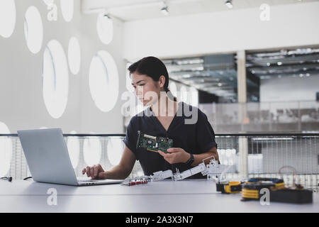 Female working on robotics Stock Photo