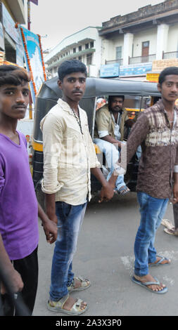 MYSURU (MYSORE),KARNATAKA/INDIA-FEBUARY 13 2018:Three young men hold hands walking on the streets in Mysorecity., Stock Photo