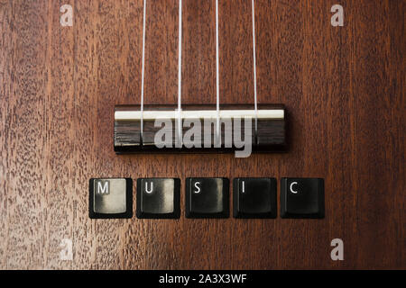 ukulele on isolated background with lettering music on white isolated background, close up view with copy space Stock Photo