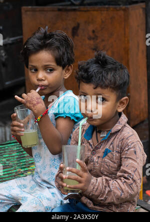 Indian children drinking lemonade in the street with plastic straws, Rajasthan, Bundi, India Stock Photo