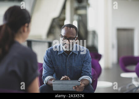 African American businessman using a digital tablet in a meeting Stock Photo
