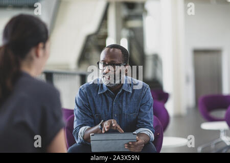 African American businessman using a digital tablet in a meeting Stock Photo