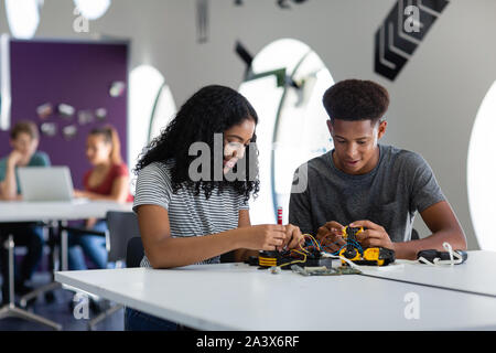 High school students working on a robotic arm in class Stock Photo