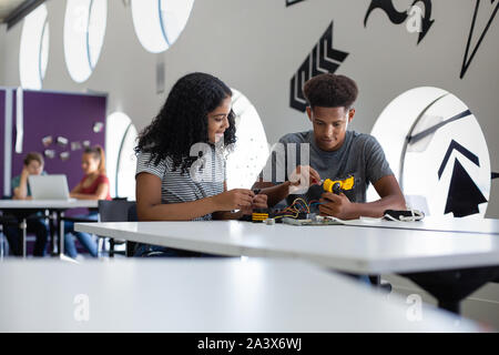 High school students working on a robotic arm in class Stock Photo