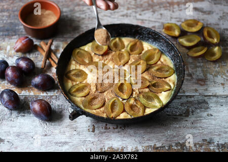 Making plum pie with sugar and cinnamon. American plum pie. Stock Photo