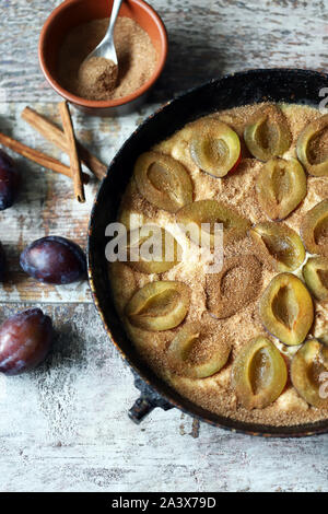 Making plum pie with sugar and cinnamon. American plum pie. Stock Photo