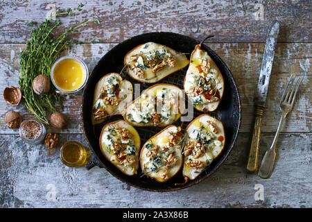Baked pears with blue cheese, honey and herbs. French cuisine Appetizer to wine. Selective focus. Macro. Stock Photo