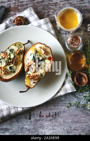 Selective focus. Baked pears with dor blue cheese on a plate. Healthy lunch. Keto diet. Keto snack. Stock Photo