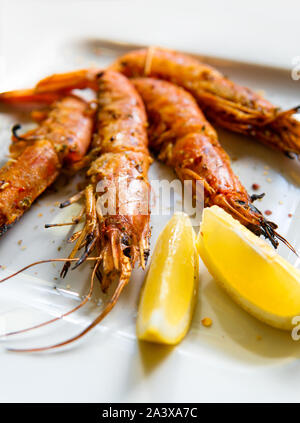 King prawns with lemon. Shrimps on a plate with lemon slices. Stock Photo