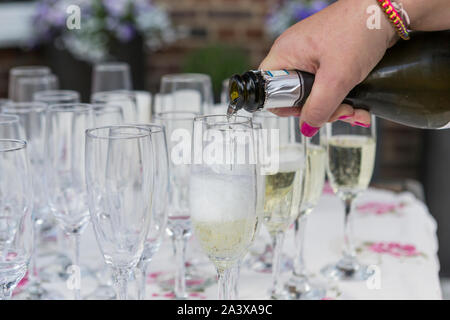 Pouring prosecco into glasses at a party Stock Photo