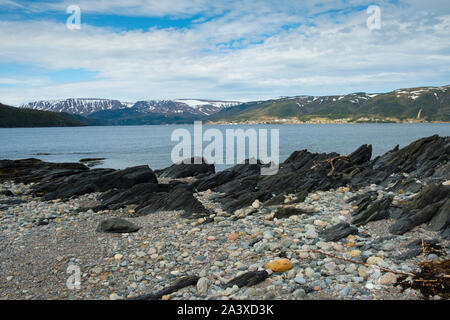 Beach at Norris Point with view across the fjord of the Tablelands and Gros Morne National Park, Newfoundland Stock Photo