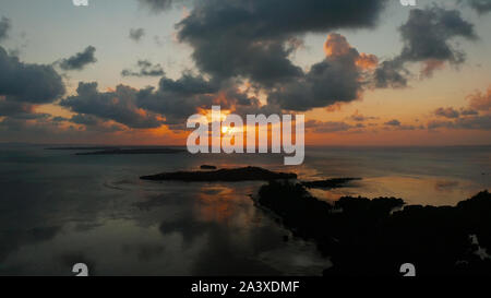 Sunset above the sea surface with waves, aerial view. Reflected sun on a water surface. Balabac, Palawan, Philippines. Sunset over ocean. Stock Photo