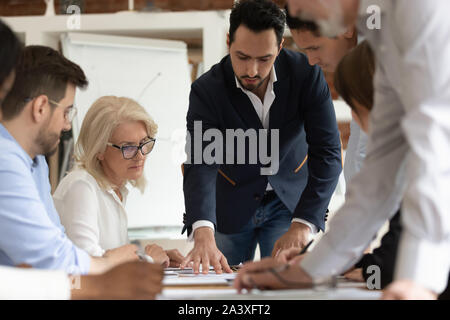 Diverse employees brainstorm discussing project at briefing Stock Photo