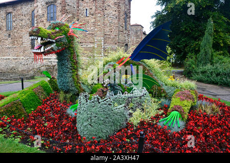 Dragon in the flowerbeds outside Colchester Castle Museum, Colchester, Essex, UK Stock Photo