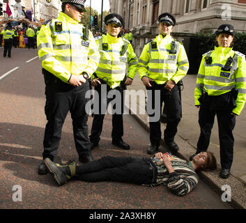 London, UK. 9th October 2019. Police arrest a protester in Birdcage Walk, Westminster, during the Extinction Rebellion two week long protest in London. Credit: Joe Kuis / Alamy News
