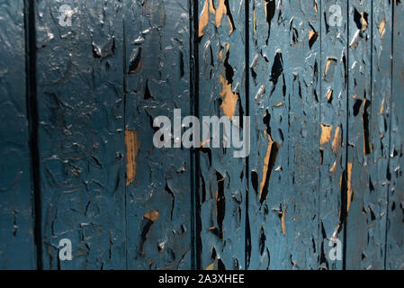 aged blue painted grunge wood texture background. Antique blue wood texture. Wooden planks shot in the sunlight at sunset. Old house is his wall. Peel Stock Photo