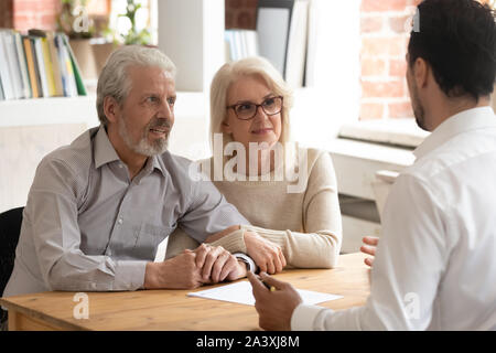Happy mature couple meeting with financial consultant in office Stock Photo