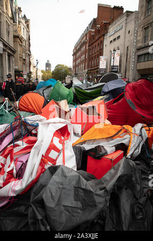 London, UK. 9th October 2019. Tents of protesters have been removed by police officers from the streets surrounding Trafalgar Square, and are seen in a heap, during the Extinction Rebellion two week long protest in London. Credit: Joe Kuis / Alamy News Stock Photo