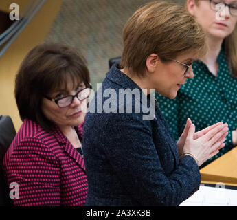 Edinburgh, UK. 10 October 2019.  Pictured: (L-R) Jeane Freeman MSP - Cabinet Secretary for Health and member of the Scottish National Party (SNP); Nicola Sturgeon MSP - First Minister of Scotland and Leader of the Scottish National PArty (SNP).  Weekly session of First Ministers Questions in the debating chamber at Holyrood. The Transport (Scotland) Bill has been a hotly debated subject which has resurfaced again today. Stock Photo