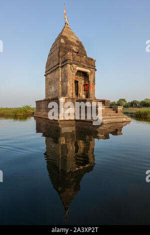 Small Hindu temple in the middle of the holy Narmada River, Maheshwar, Madhya Pradesh state, India Stock Photo