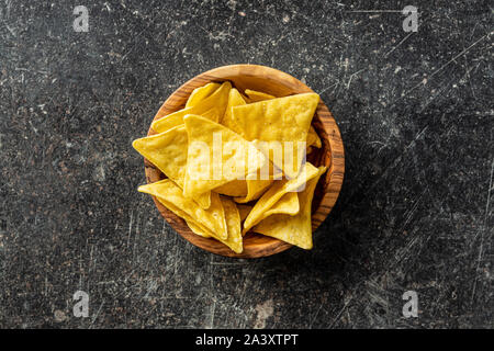 Corn nacho chips. Yellow tortilla chips in wooden bowl. Top view. Stock Photo