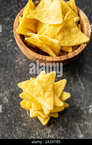 Corn nacho chips. Yellow tortilla chips on old kitchen table.