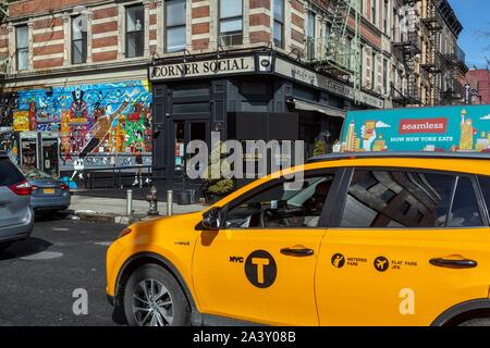 YELLOW TAXI IN FRONT OF THE CORNER SOCIAL IN HARLEM, MALCOLM X BOULEVARD, MANHATTAN, NEW YORK, UNITED STATES, USA Stock Photo