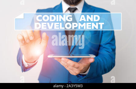 Handwriting text Coding And Development. Conceptual photo Programming Building simple assembly Programs Businessman with pointing finger in front of h Stock Photo