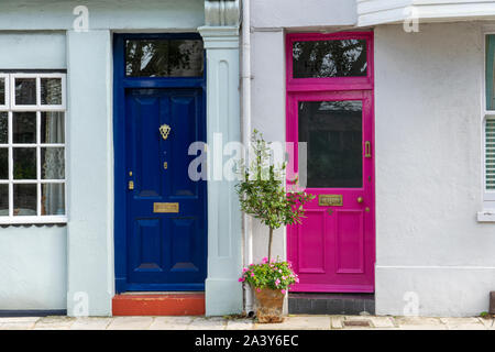 Two colourful front doors side by side one blue and one pink Stock Photo