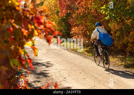 Montreal, CA - 10 October 2019 Cyclist riding a bike on Des Carrieres cycle path in Autumn. Stock Photo
