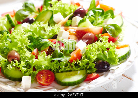 Mediterranean-style salad with kalamata olives, feta cheese, different tomatoes, lambs lettuce, cucumber and lettuce. Greek salad. Stock Photo