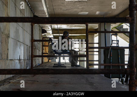 A homeless man under an overpass sitting on a bench Stock Photo